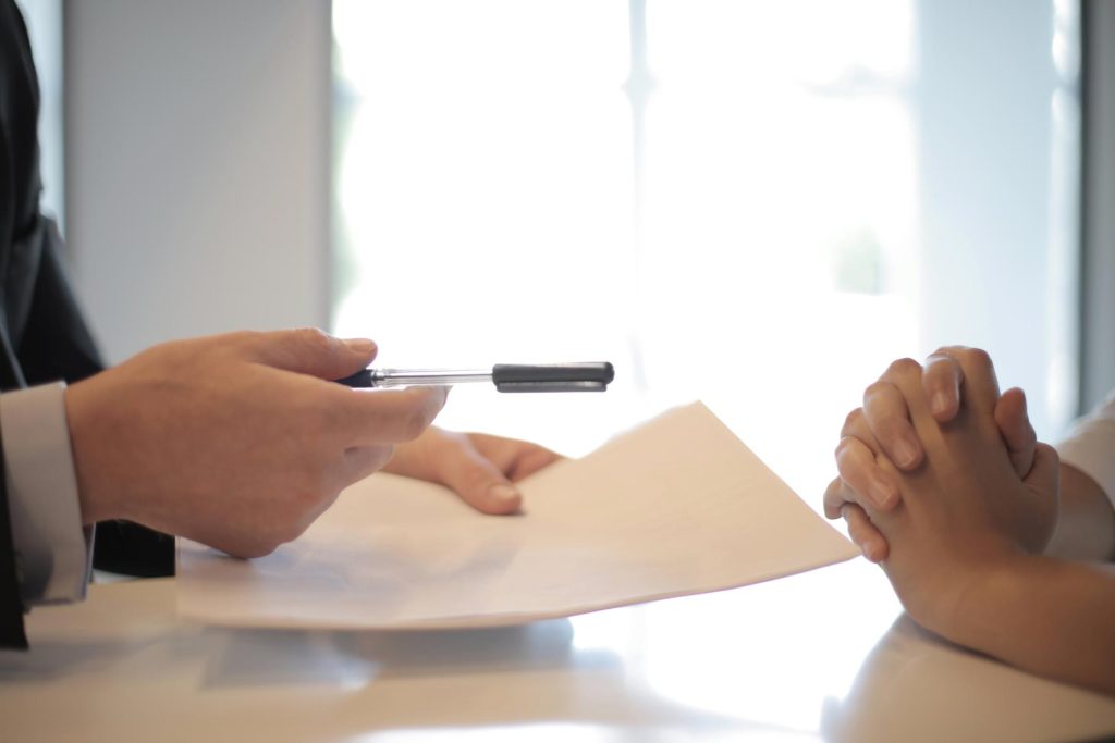 Investment Management in Cheshire 19 A hand holding a piece of paper and a pen