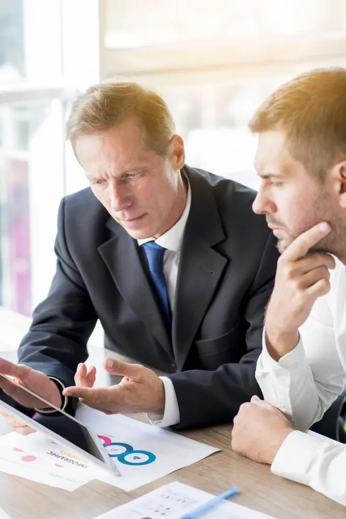 two-businessman-discussing-business-plan-digital-tablet