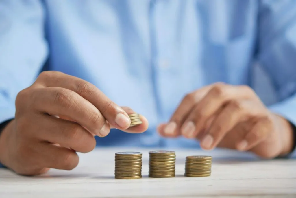 Tips for Investing 12 a person stacking coins on top of a table