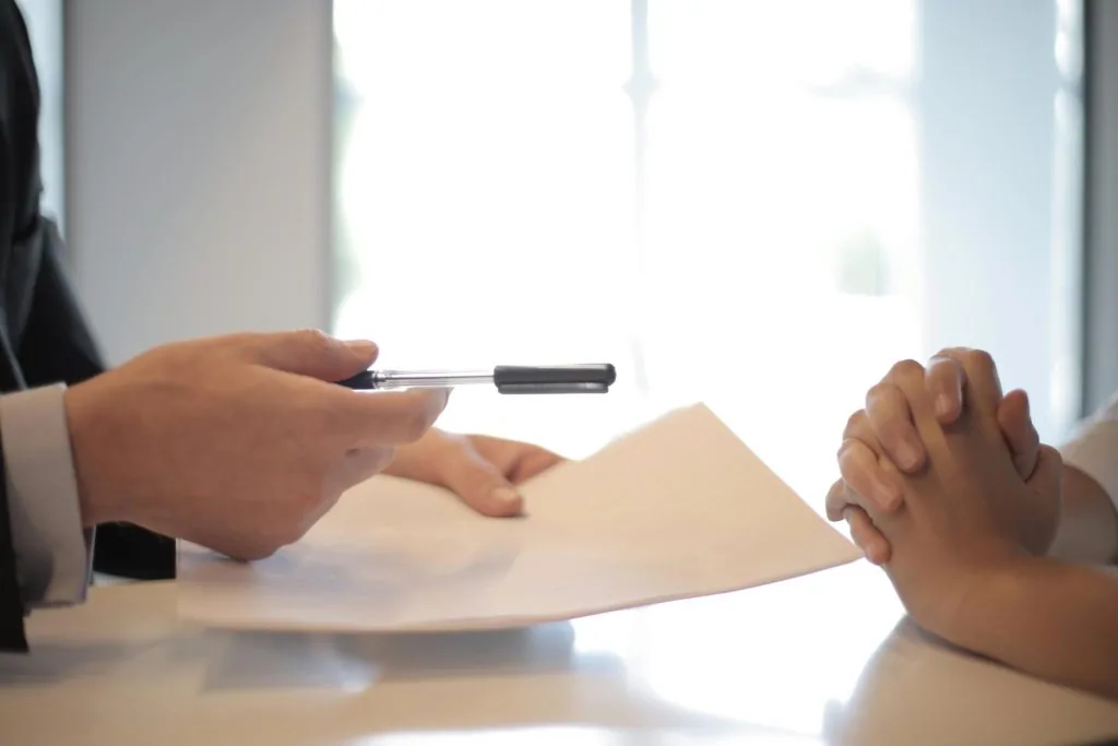 Investment Management in Cheshire 19 A hand holding a piece of paper and a pen