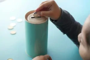 Retirement Planning 7 A hand putting money into a tin
