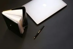 A paper, pen and book on a table